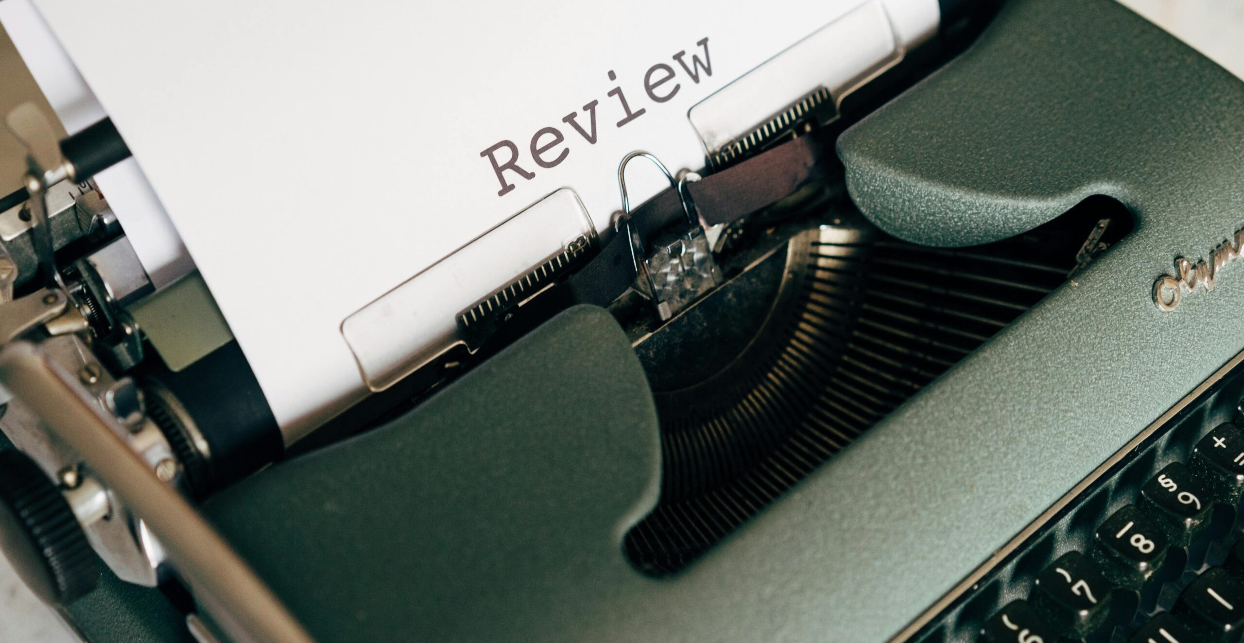 A typewriter with a page reading "Review"